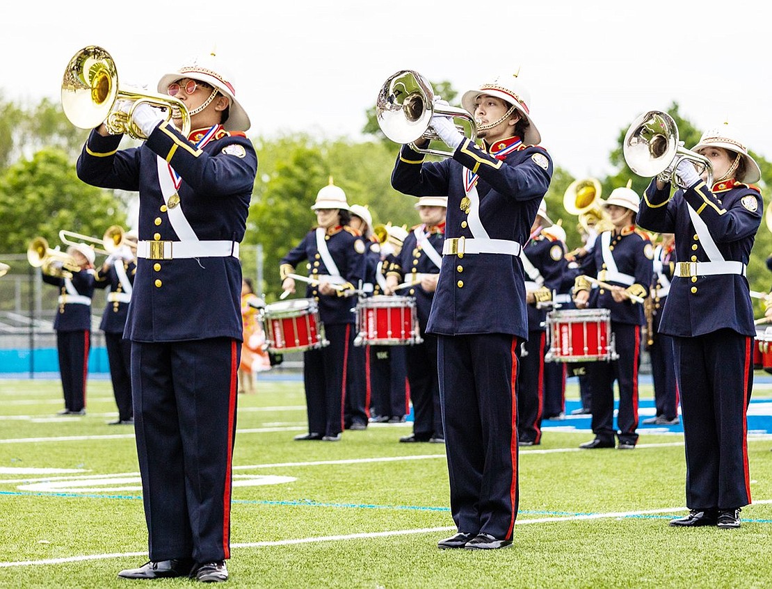 From left, Chris Soria, Christian Ceja and Kate Richardson play baritone in the foreground with the rest of the Port Chester High School Marching Band and Color Guard performing around them during a recreation of the band’s fall field show.