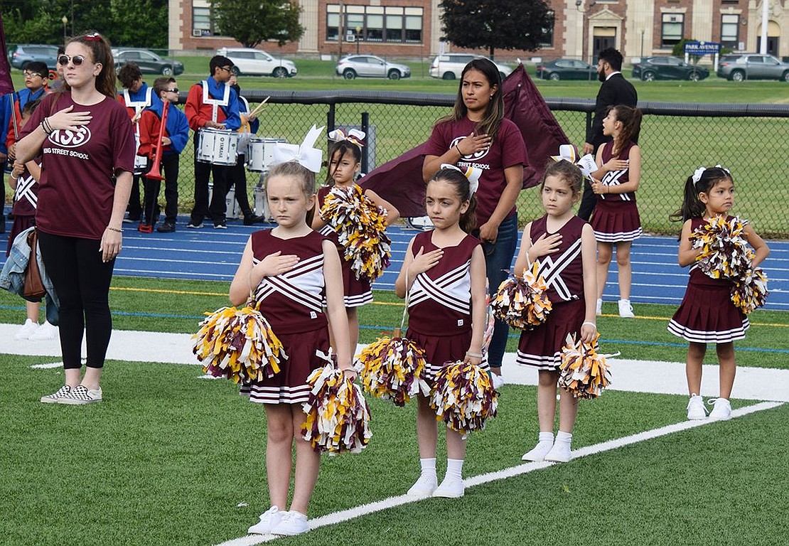 Members of the King Street School spirit squad and their coaches put their hands over their hearts while the Port Chester High School Marching Band plays The National Anthem at the beginning of the night.