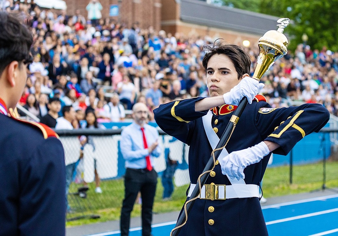 Port Chester High School Marching Band member Jordie Perez hands off the staff of parade drum major to Thomas d’Esperies.