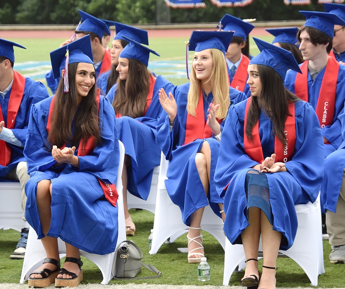 Danielle Cappelli (left) and Vivian Carvalho make eye contact and smile over a funny moment during the commencement ceremony, soaking in their last few minutes as Blind Brook High School students.