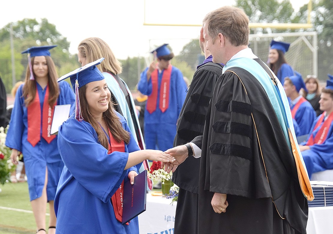 Madison Muoio carries herself with a massive grin as she approaches Superintendent Dr. Colin Byrne for a handshake upon receiving her diploma.