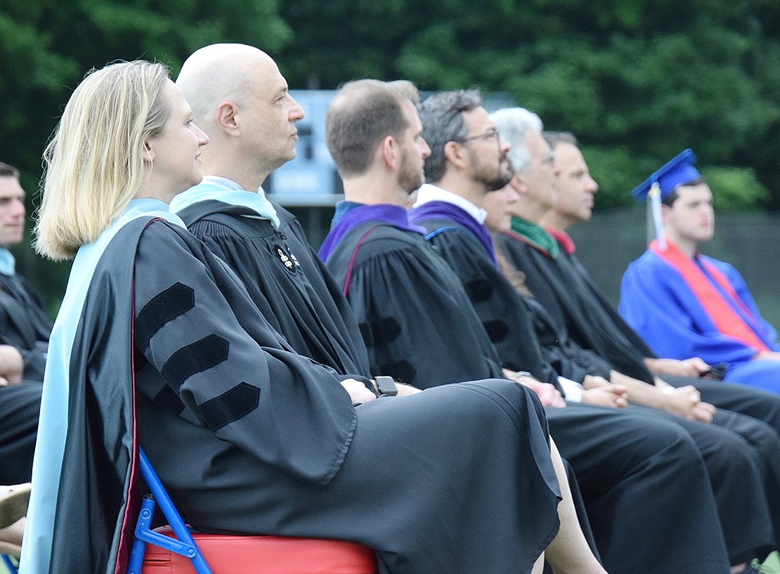 Donning their traditional graduation robes, Blind Brook High School Principal Jennifer Chirles and Assistant Principal Mark Greenwald sit by Board of Education members and proudly look over their departing students.