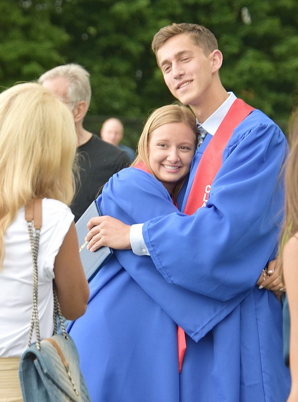 As official graduates, Amanda Drazka and Jordan Cassuto share a sweet hug as they say goodbye to their high school days for good.