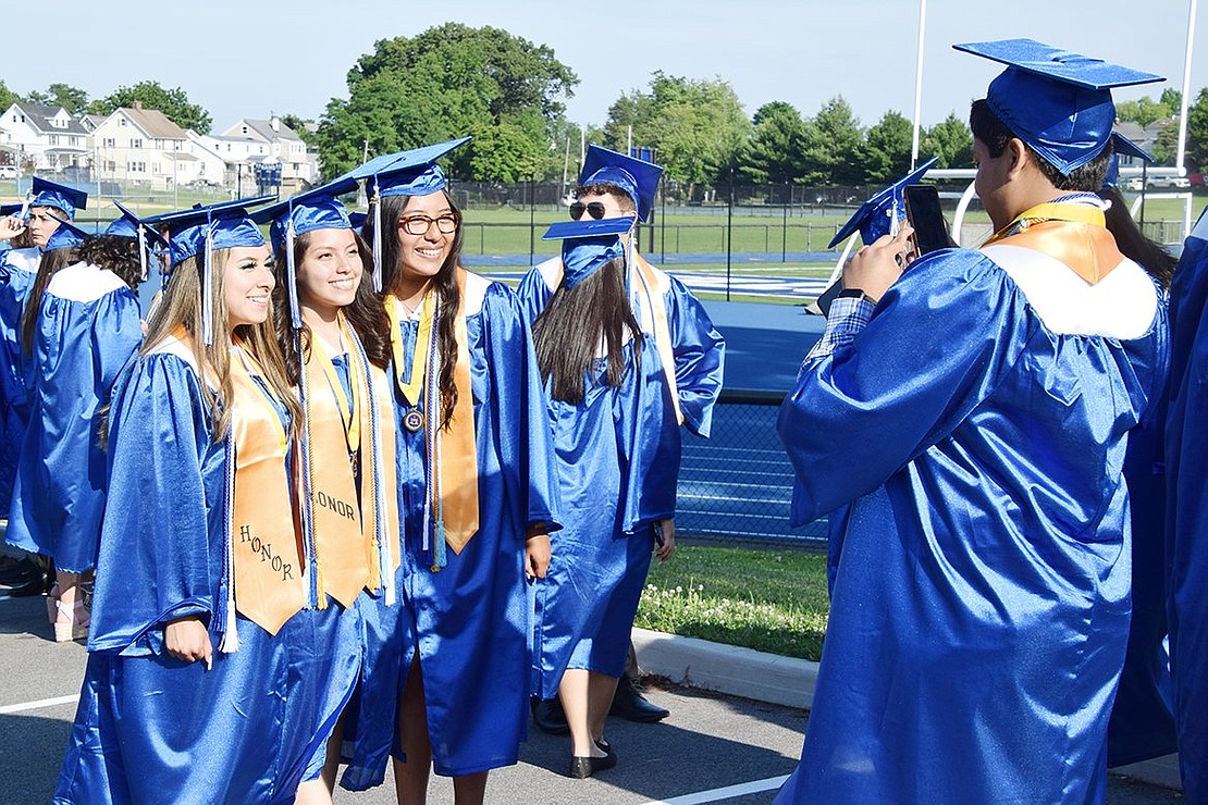 Before the graduation ceremony begins, soon-to-be graduate Alexi Navichoque takes a photo of Dyana Sandoval (left), Allyson Lunarejo and Jocelyn Herrera in their final moment as high schoolers.