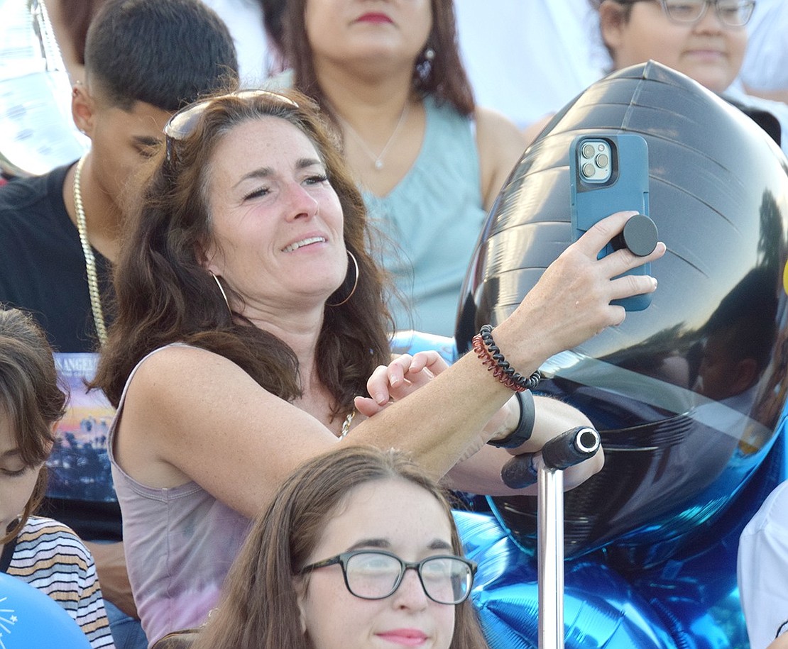 With a proud grin stretched across her face, Layfette Drive resident Amanda Ortiz takes a phone out to record Daphne Sullivan as she recites her salutatory address.