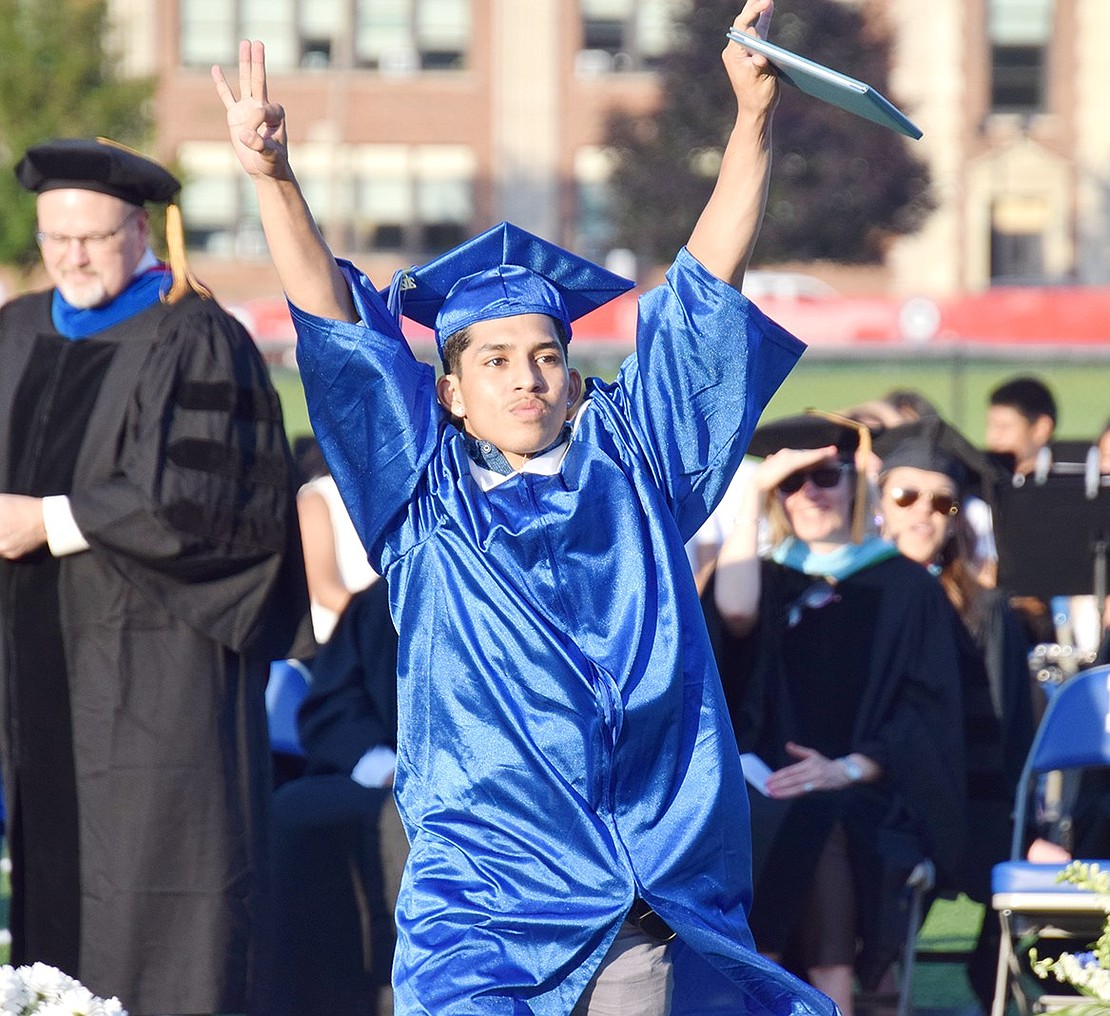 With sincere pride on his face, Nicholas Bolanos throws his arms in the air with a diploma in hand and turns toward the airhorns that started blaring when his name was called.