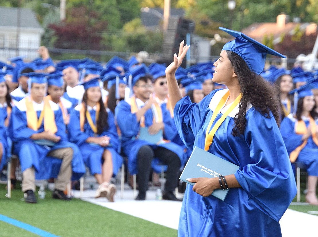 As if she were the Queen of England herself, Amy Munguia waves to the crowd with esteemed elegance as a new Port Chester High School graduate. 