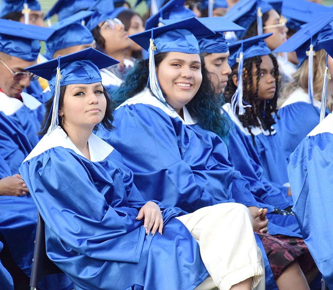 Minutes away from becoming official graduates, Jasmine Flores (left) and Gabriela Flores smile together as they patiently wait for the presenting of diplomas.