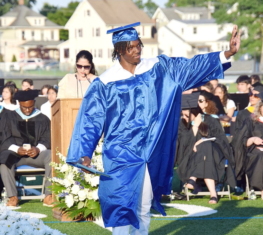 Kameron Clayton waves to loved ones after receiving his degree.