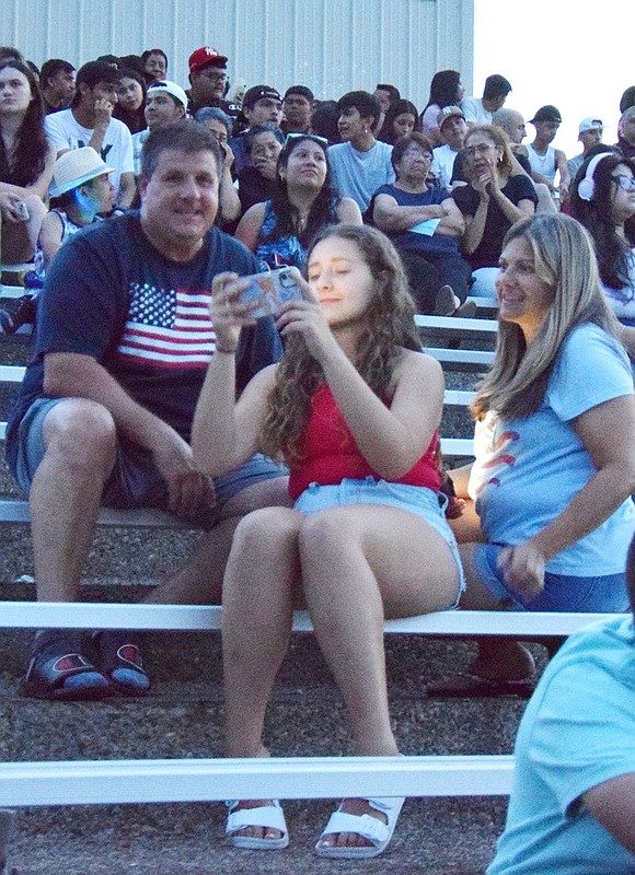 Ricky, Karen and Jenna Provenzano of Quintard Drive, who are related to skydiver Jeff Provenzano, wait in the stands for the fireworks to begin.