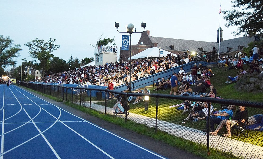 The stands at Port Chester High School’s Ryan Stadium as well as the grassy areas around them are filled for the Fourth of July festivities on a perfect July night.