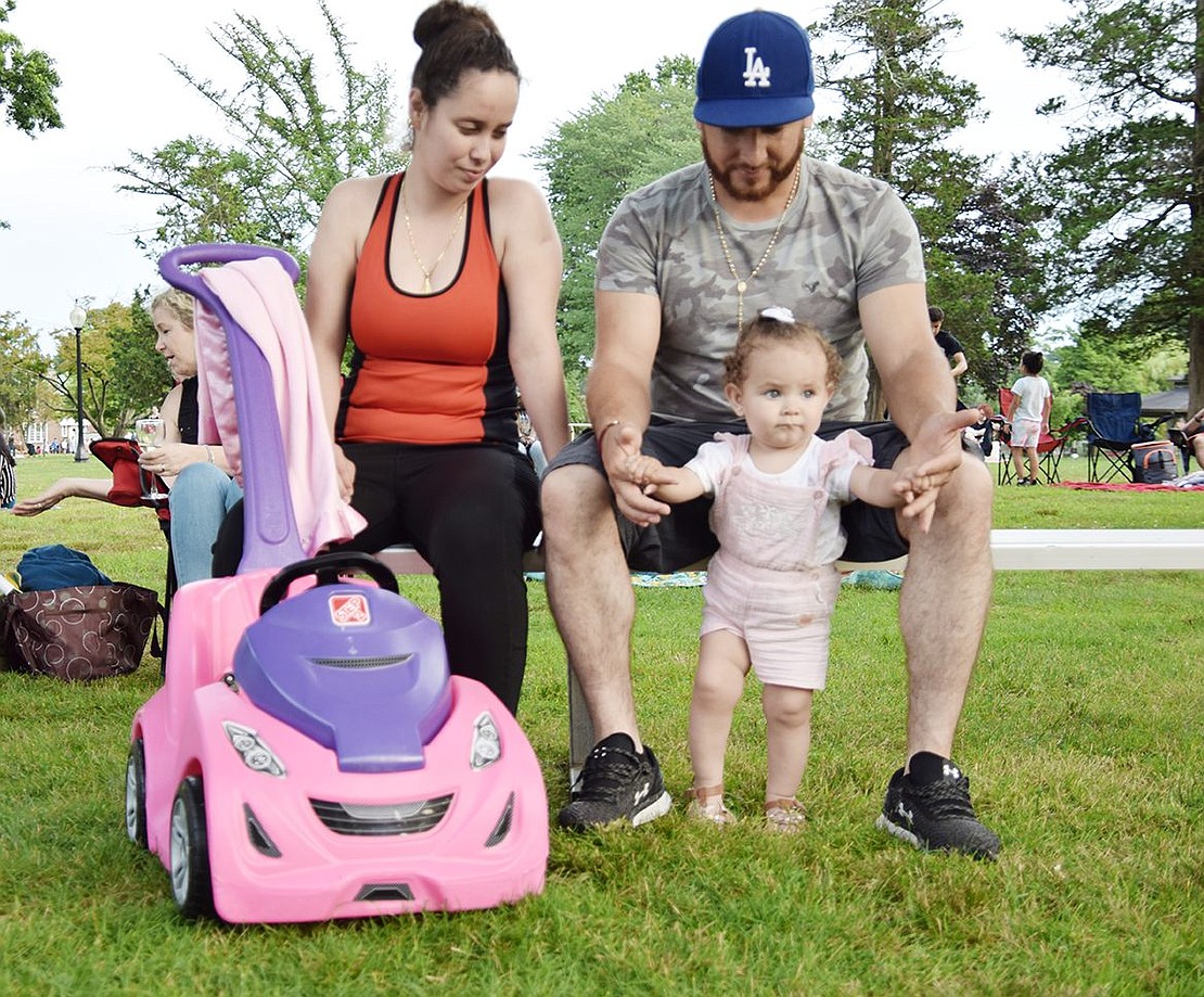 Making the short trek with her family to see the show from her Maple Place home, 1-year-old Crystal Ochoa dances to the performance, supported by her father Juan, while her mother Alejandra laughs.