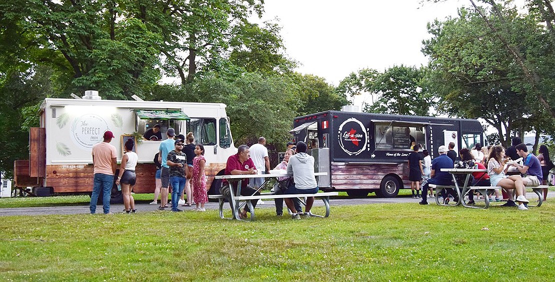 Goza concert-goers line up at the two food trucks, Latusion and The Perfect Mix, which serve Peruvian and Cuban food, respectively.