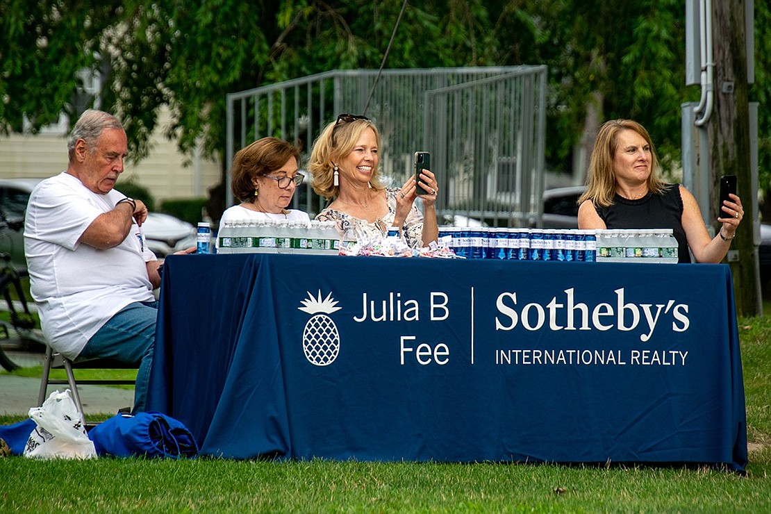 Tom Rogull (left), Maria Stilo, Kicki Storm and Joni Alexopoulos watch Kickin’ Nash perform from their Julia B. Fee Sotheby’s International Realty table, where they also hand out free bottled water and bubbles. The firm sponsored the Music in the Park series, which will host Bealy Dan on Wednesday, Aug. 3.