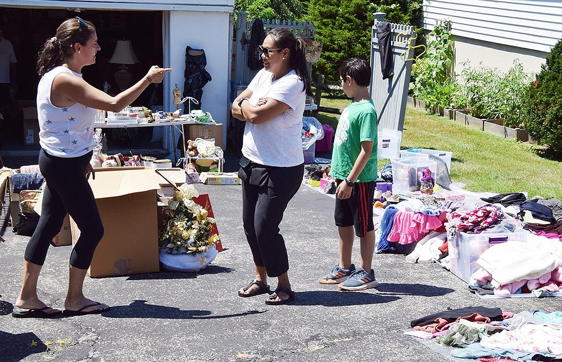 Jessica Zunic (left) mans the merchandise at 28 Valley Terr., the home of her parents. She engages with customer Annie Chandrapong of Rye Brook, accompanied by her 10-year-old son Max Dumbroff. By 1:30 p.m. Zunic said they had sold about half the items they had originally put out.  