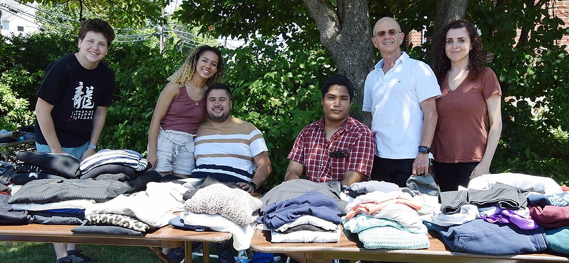 Lots of clothing is for sale at the Foster Teen Network’s tables on the lawn at 62 Bowman Ave. Volunteering at that location are Ian Goldfeld (left), intern Maria T. and her boyfriend David, Michael, Executive Director Michael Goldstein of Rye Brook, and Briggitte Dix, a board member. Any leftover goods were picked up by Don Bosco Center.