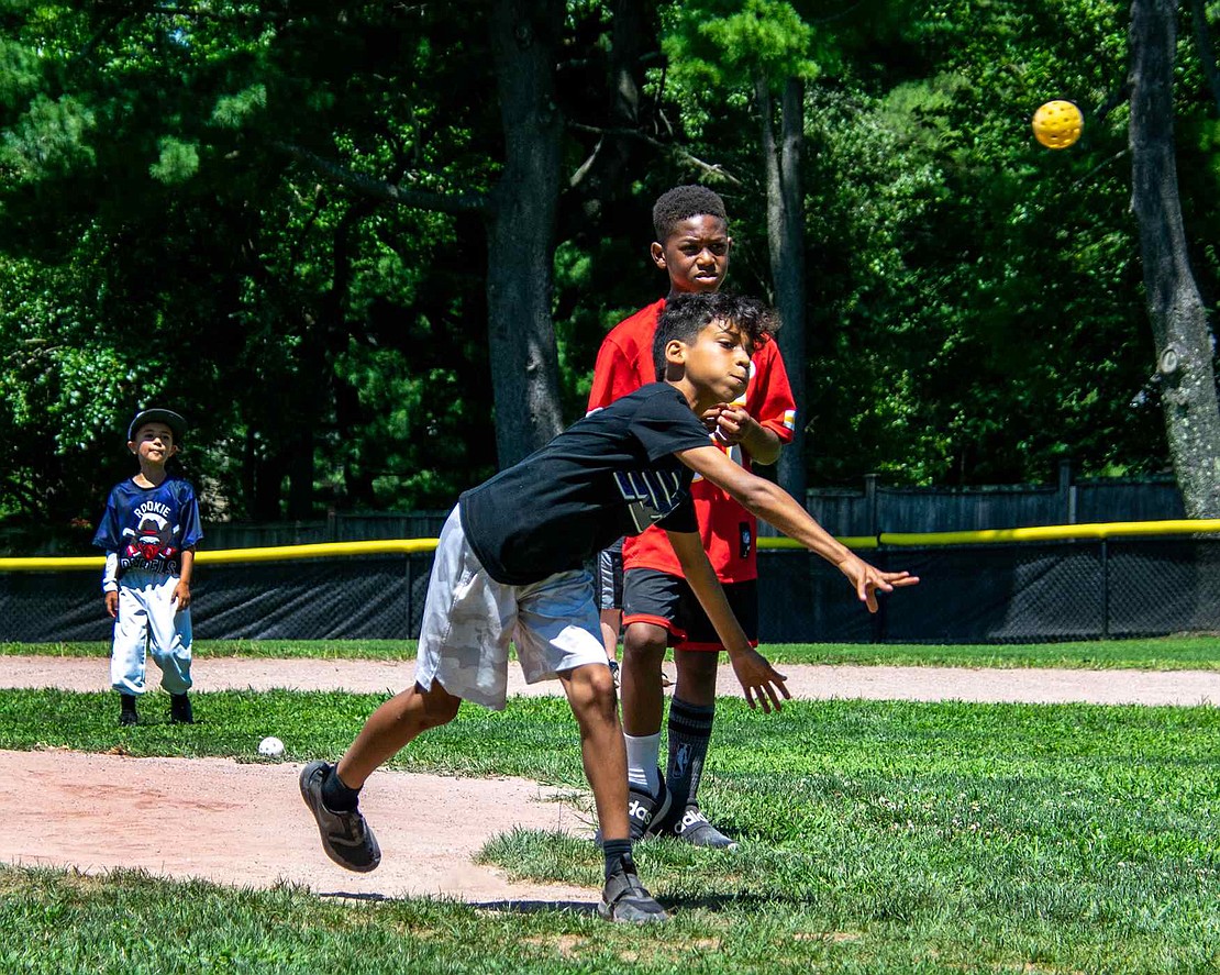 In a display of pure athleticism, Port Chester 11-year-old Fabio Garcia pitches a whiffle ball during a children’s game on one of the Pine Ridge Park baseball fields. The Glen Avenue resident is observed by teammate Tariq Williams, 8, of Berkley Lane.