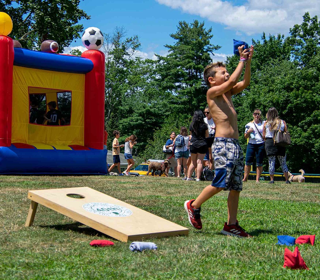A bean bag connects with 8-year-old Eli Hazan’s eager, open hands. But someone might want to tell the Brush Hollow Lane resident that cornhole doesn’t usually involve catching the sack.