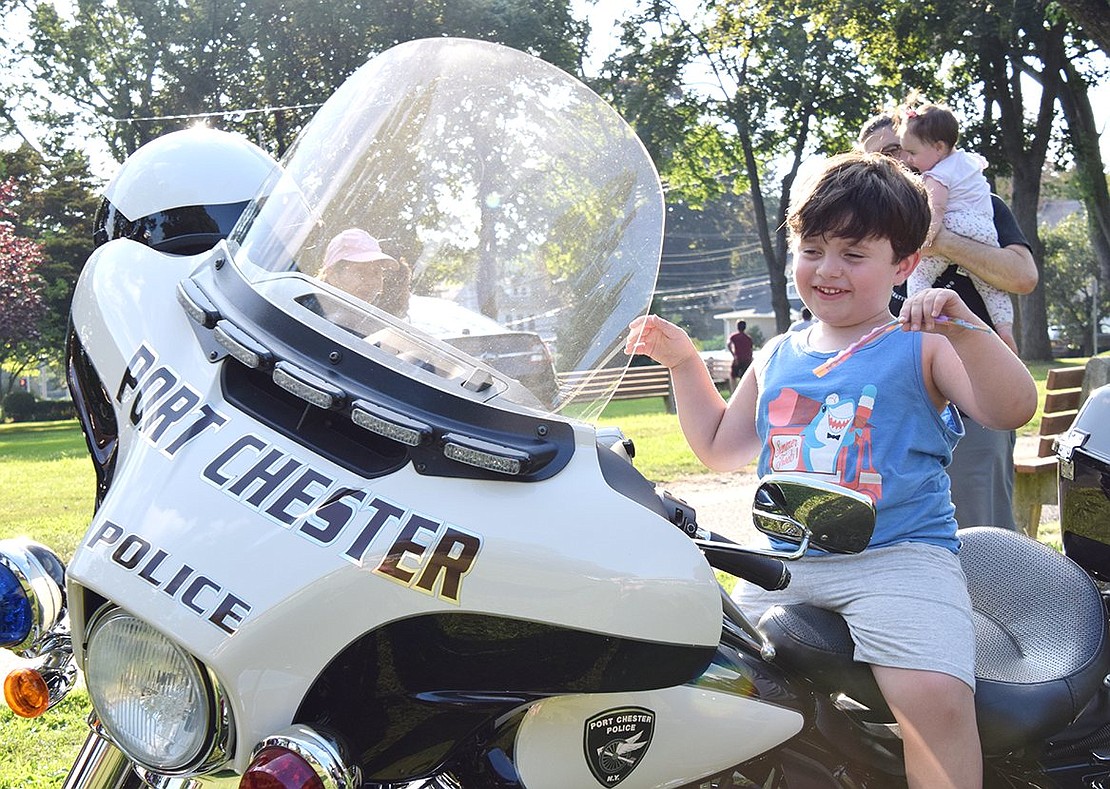 South Regent Street resident Matteo Imbesi, 3, couldn’t be happier dancing on top of a Port Chester police motorcycle during the National Night Out event at Lyon Park on Tuesday, Aug. 3. The annual festival is meant to embolden the relationship between law enforcement and the community, and true bonds start young.