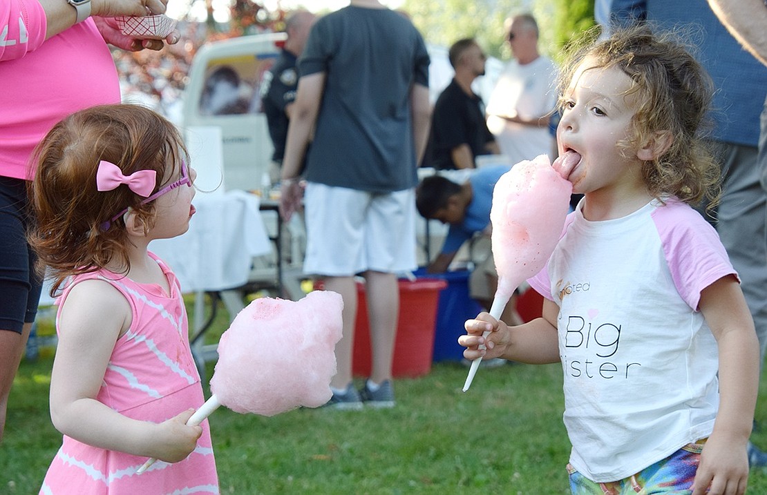 Helena, daughter of Port Chester Police Officer Leonard Carriero, takes a big, juicy lick from a fluff ball of cotton candy while her friend Ava Pennella watches in awe. The 2-year-old buddies both reside in Port Chester.