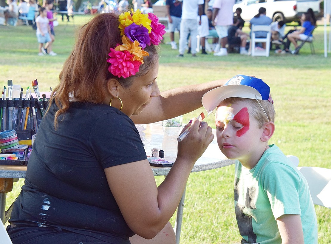 Patiently holding still for an artful face painting session, Westchester Avenue resident Terry Kelly sits tight so he can transform into the superhero The Flash. The 6-year-old is the nephew of Port Chester Police Captain Charles Nielsen.