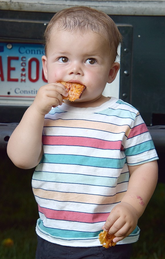 After offering his slice to Colony Grill food truck employees, Indian Road resident John Fragiacomo accepts their polite rejection and becomes a true New Yorker by thoroughly enjoying his first pizza experience at 16 months old.
