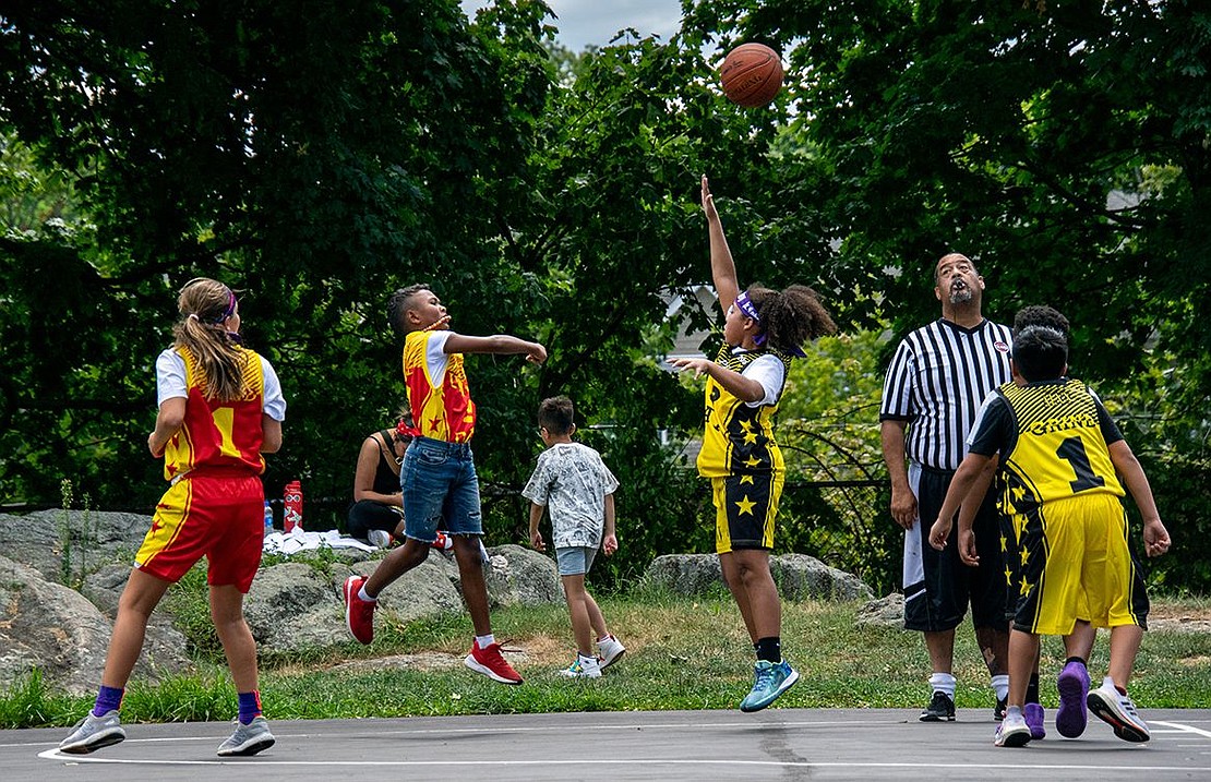 Aliyah Salmon, a Port Chester Middle School rising seventh-grader, jumps for the ball after SJ Williams, a Thomas A. Edison Elementary School rising fifth-grader, whipped it over her head during a basketball game at Unity Day in Columbus Park on Saturday, Aug. 13. Basketball tournaments are a staple of the annual event, which is meant to bring together current and former residents of Port Chester Housing Authority buildings.