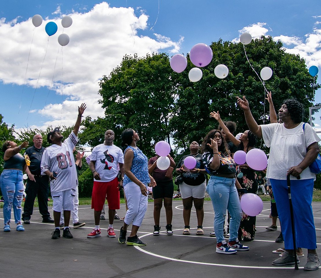 Pink, blue and white balloons are released into the air during a small ceremony recognizing deceased loved ones, with each inflatable representing the love and memories held by the releaser for the person or people they lost.