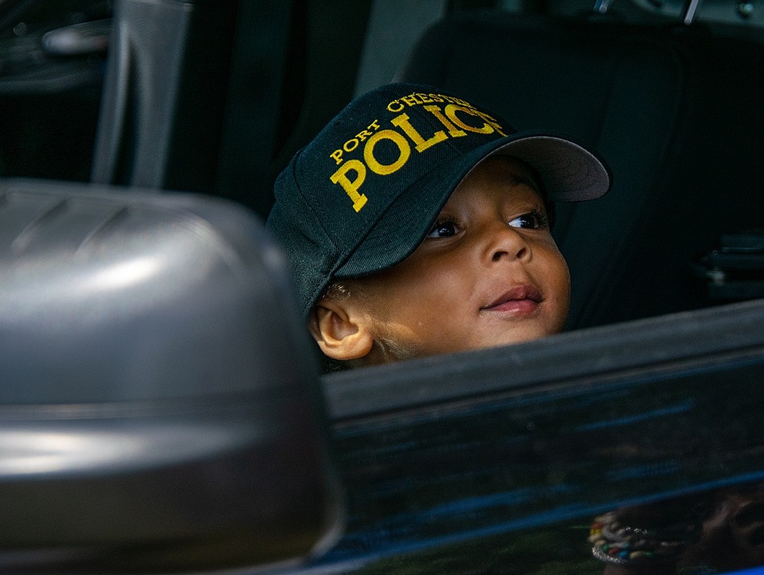 Omari Talbert, 3, is mesmerized by the lights and sirens of the Port Chester police cruiser he sits in. Grandson of Patrice Kemp, pastor of St. Frances AME Zion Church in Port Chester, the Poughkeepsie resident feared the vehicle at first, but once he got inside, laughter replaced his apprehension.