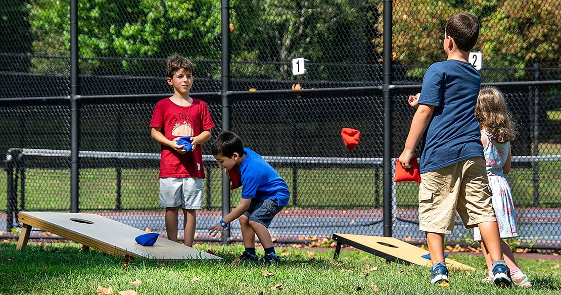 Eli Ferrari (left), a rising third-grader at Ridge Street Elementary School, is mesmerized by his peer Justin Crasper’s beanbag toss. The two play a game with Crasper’s younger siblings Brett and Chloe, twins who are about to enter kindergarten.