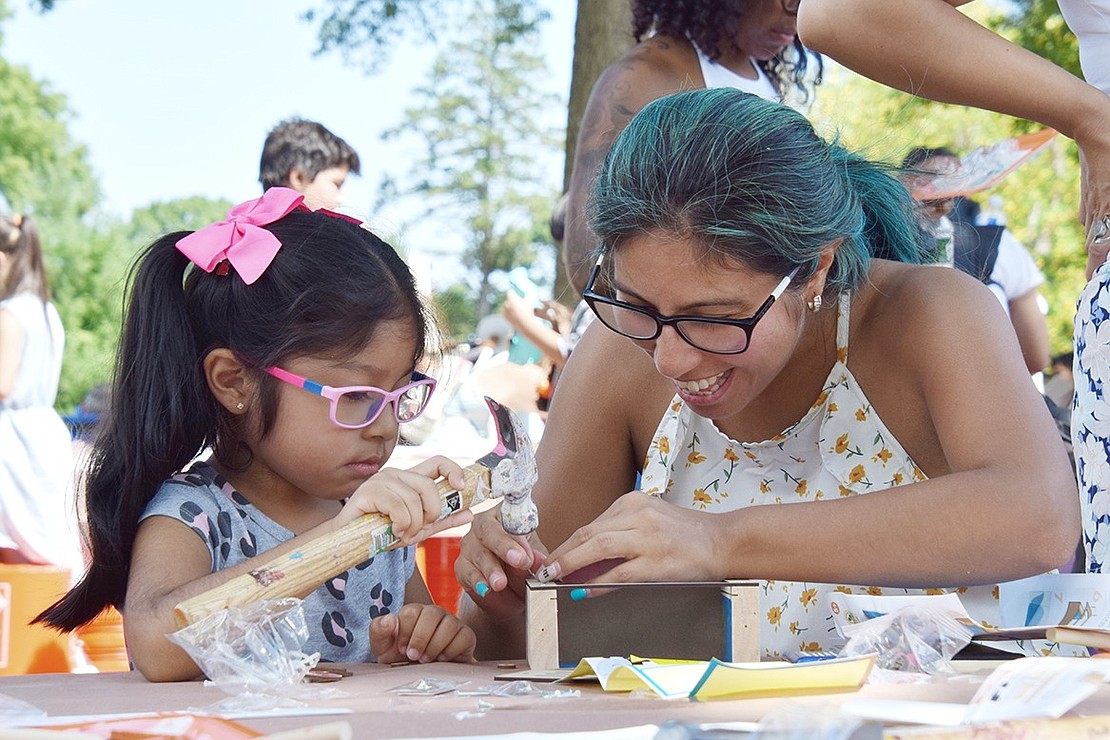 Making memories to last a lifetime, Port Chester resident Jessica Flores is all smiles as she helps her 4-year-old daughter Kaitlyn Salazar nail together a wooden sailboat at The Home Depot arts and crafts table during the 33rd annual Port Chester Day at Lyon Park on Saturday, Aug. 27.