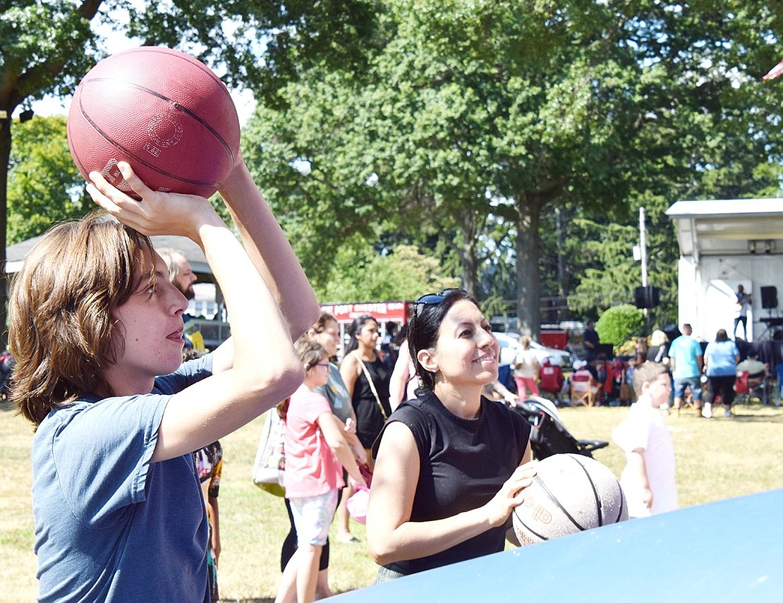 Traveling from White Plains for some family bonding, Cathy Grande and her 13-year-old son Michael shoot hoops together at the inflatable basketball game.