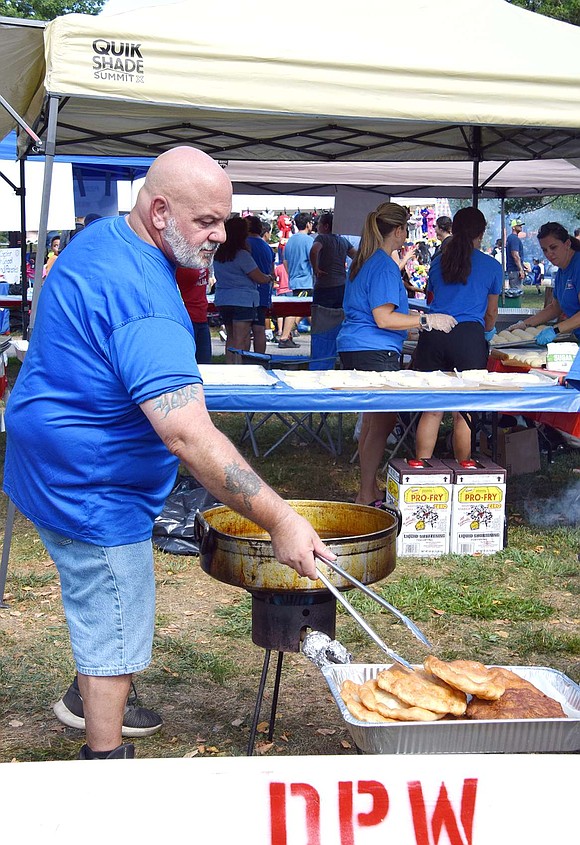 Serving up a traditional favorite at the Italian Heritage Club booth, Mark Scocchera sets aside fried dough for pizza fritta.