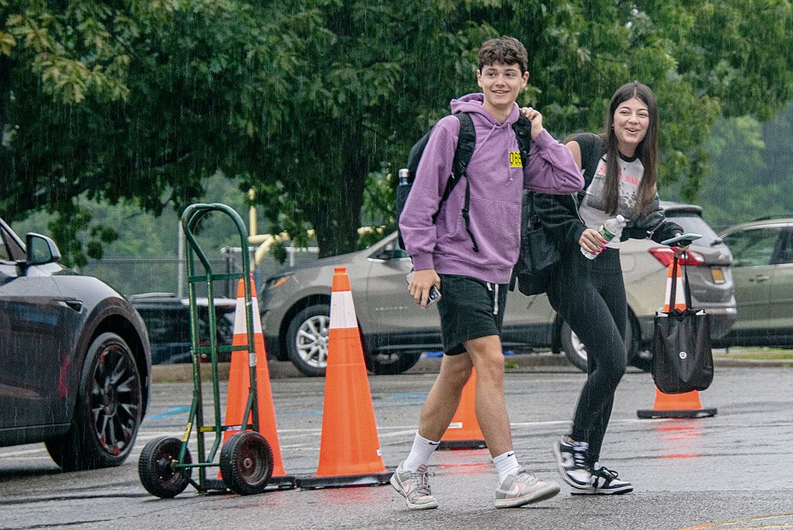 Cooper Schloss (left) and Chloe Beal make their way to the front doors of the Blind Brook Middle/High School for the start of their sophomore year on Tuesday Sept. 6. Smiling at peers in the parking lot, the students are getting dropped off for their first day of classes.