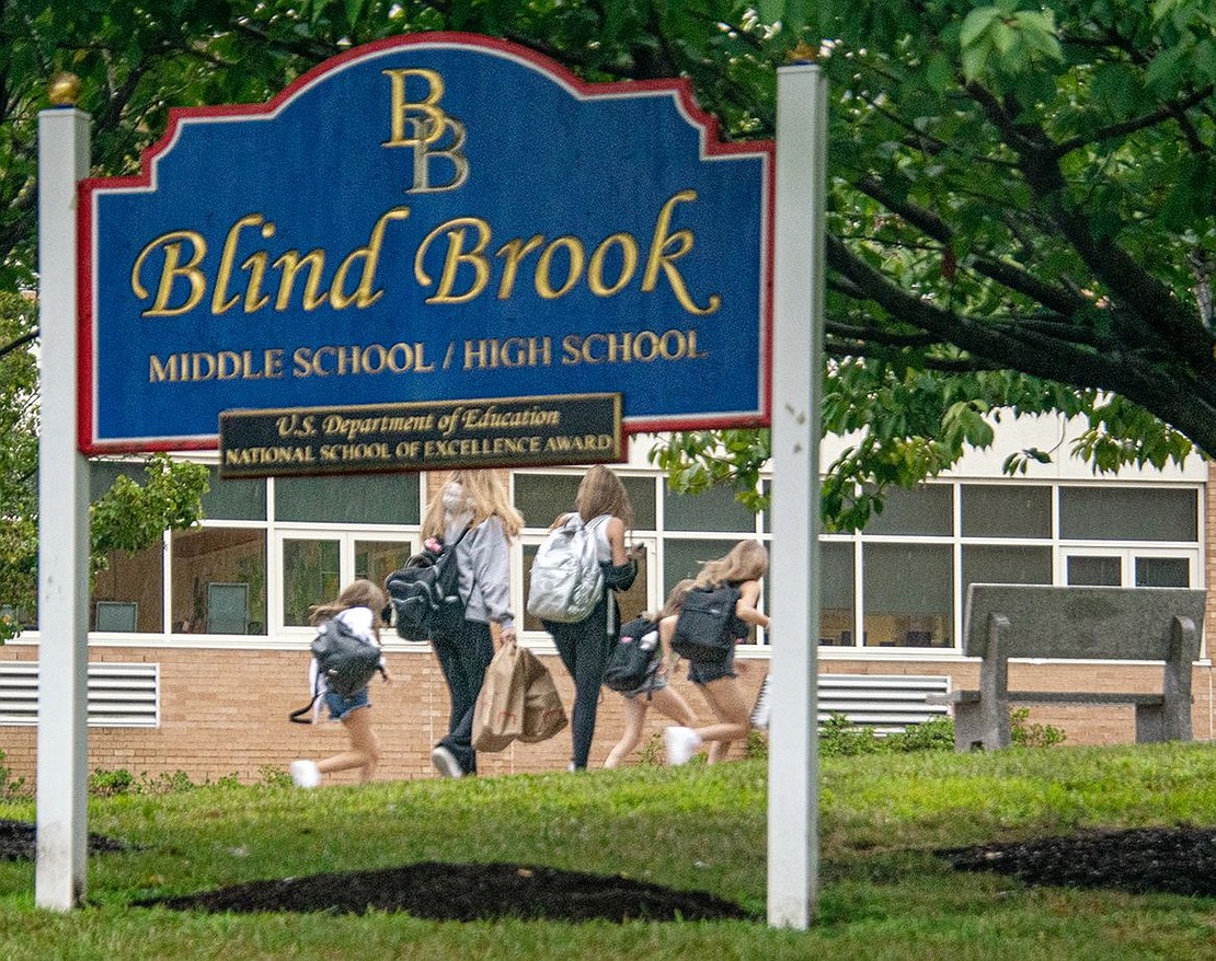 As quickly as they can, students sprint toward the front doors of Blind Brook Middle/High School, attempting to avoid the rain on their first day.