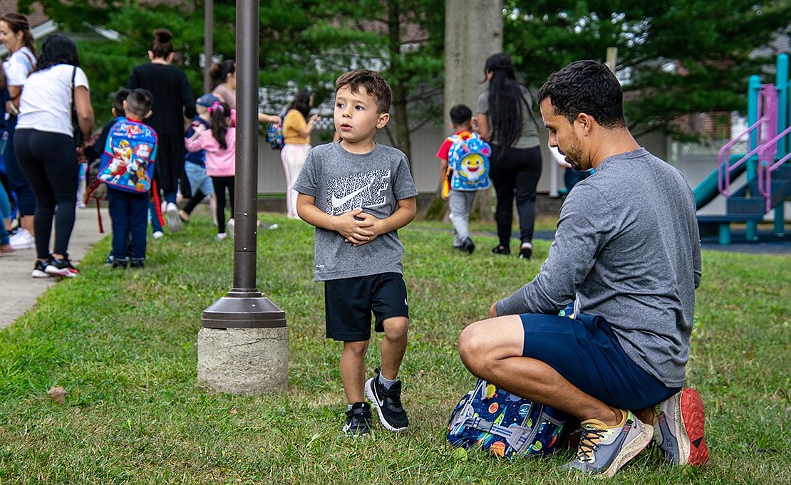 Julian Ochoa looks toward the kindergarten classroom he just left at King Street Elementary School after the second day of the 2022-23 year on Wednesday, Sept. 7. His dad Fabian repacks his bag as the two prepare to go home.