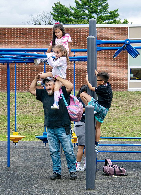 Sophia Labrusciano gingerly lets go of the monkey bars to sit atop her father Angelo’s shoulders. The second-grader and her classmate Chelsea Cate (above) released their pent-up energy at a King Street Elementary School playground.