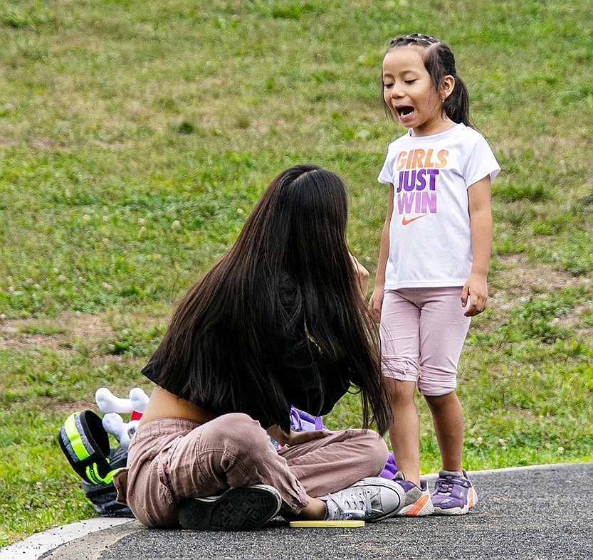 Amalia Zhunio, a King Street Elementary School kindergartener, shrieks with excitement as she checks in with her family member Cristina after a hard round of playing at the playground.