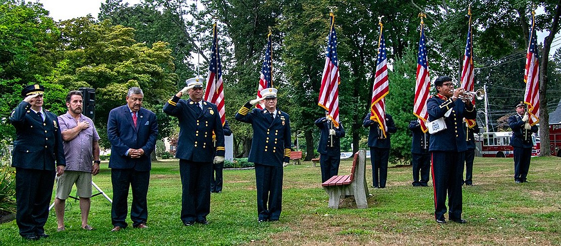 Port Chester High School senior Christopher Mendoza plays Taps as Village Trustees and members of the Fire and Police Departments salute, place their hands over their hearts or bow their heads in respect.