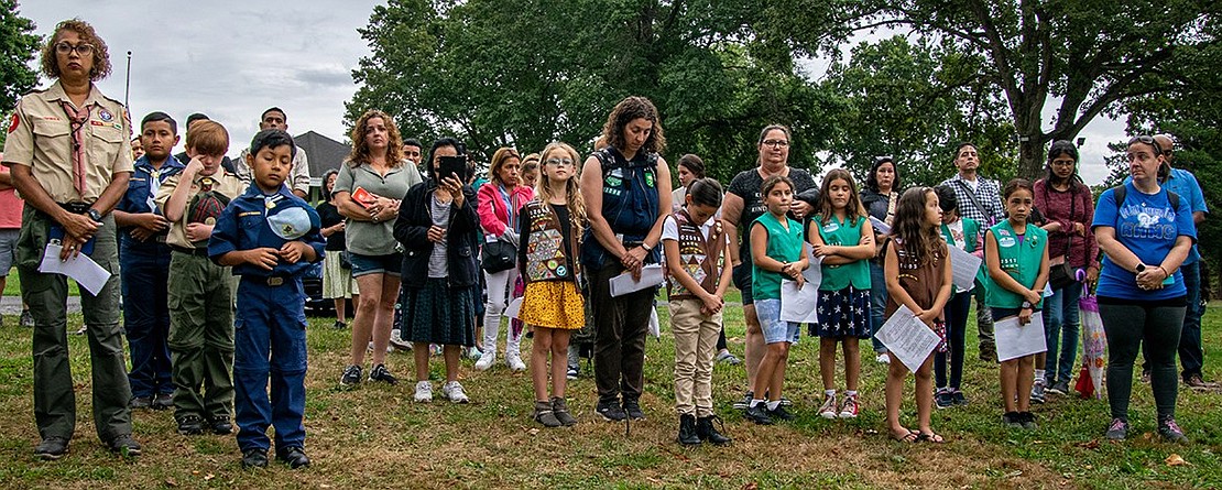 Local Scouts, their parents and over a dozen other community members bow their heads in prayer or respectfully look on as others do while Iglesia Pentecostal El Olivar Reverend José Cruz delivers the benediction.