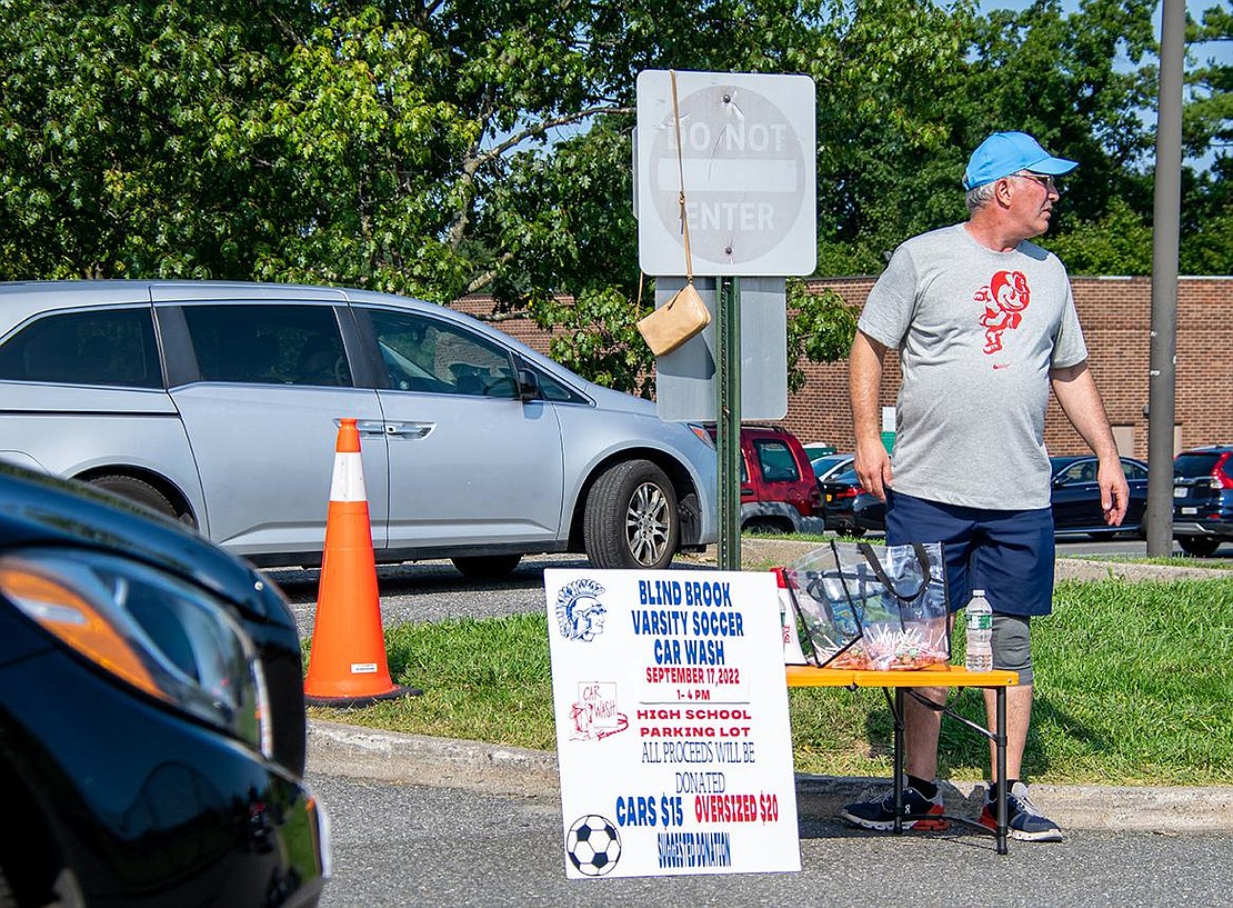 Gary Karetsky, the father of Blind Brook boys’ soccer captain and defenseman Daniel, directs traffic heading to the car wash in the parking lot of Blind Brook Middle/High School. Washes were $15 for cars and $20 for “oversized vehicles.