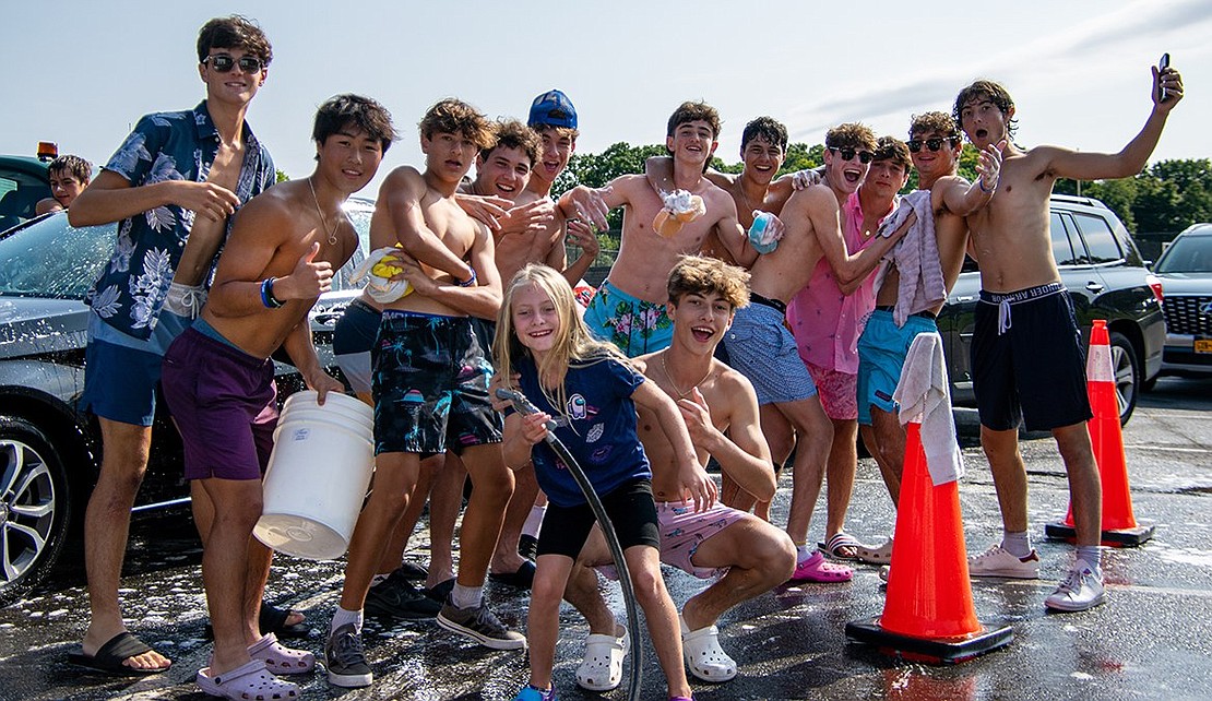 Members of the Blind Brook boys’ soccer team pose for a group photo between car washes. Sloane Berman, the younger sister of junior midfielder Michael (front, crouched) helped the Trojans for a while. The $3,200 raised from the fundraiser is going to the Don Bosco Community Center, Abilis and Coffee for Good, all based in either Port Chester or Greenwich, Conn.