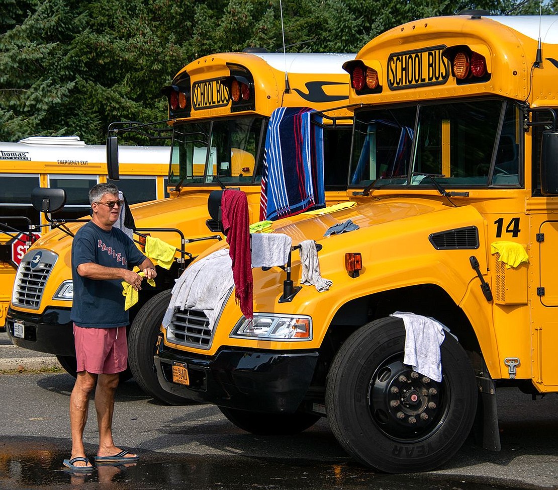 Dusan Cuk, father of sophomore goalie Luka, hangs rags and cloths out to dry on a school bus for later use in the wash line. The Maplewood Lane resident helped the boys during Saturday’s event.