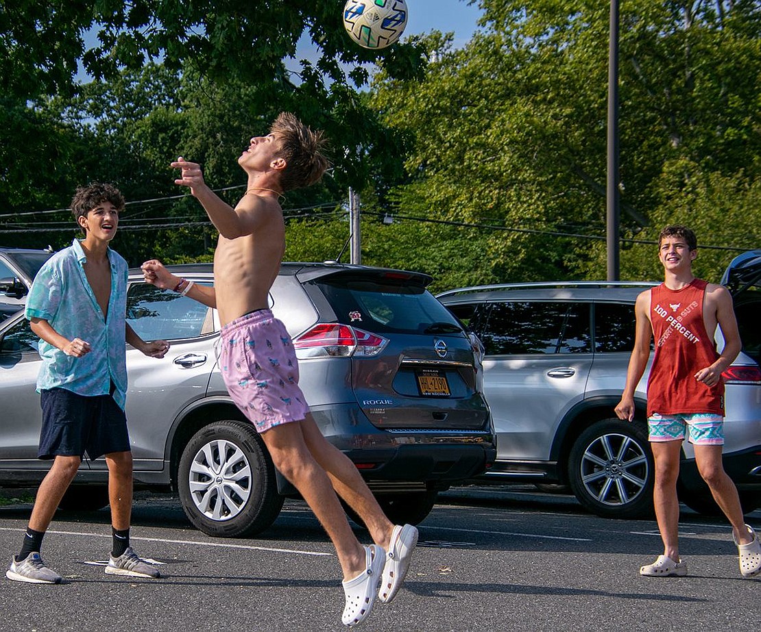 Taking a break to practice their skills, junior midfielder Michael Berman heads a soccer ball in a small game he plays with sophomore goalie Luka Cuk (left) and junior midfielder Ethan Leland (right).