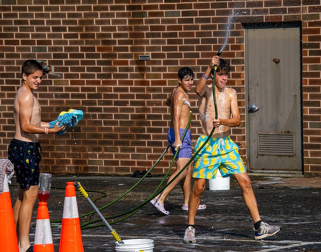 Hoses may be great for washing cars, but they’re even better for spraying teammates. Sophomore midfielder Dylan McRedmond wields his wet weapon as junior midfielder Martin Otero walks behind him. Bryce Oling, a senior midfielder, holds two soaked sponges, ready to throw them at a teammate.