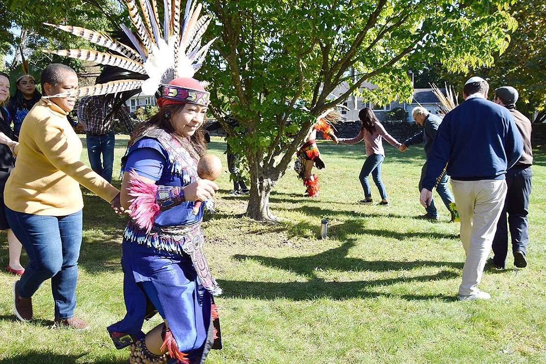 Aztec dancer Xochitl Blanca Gomez of Port Chester leads attendees in a dance encircling a tree on the church grounds.