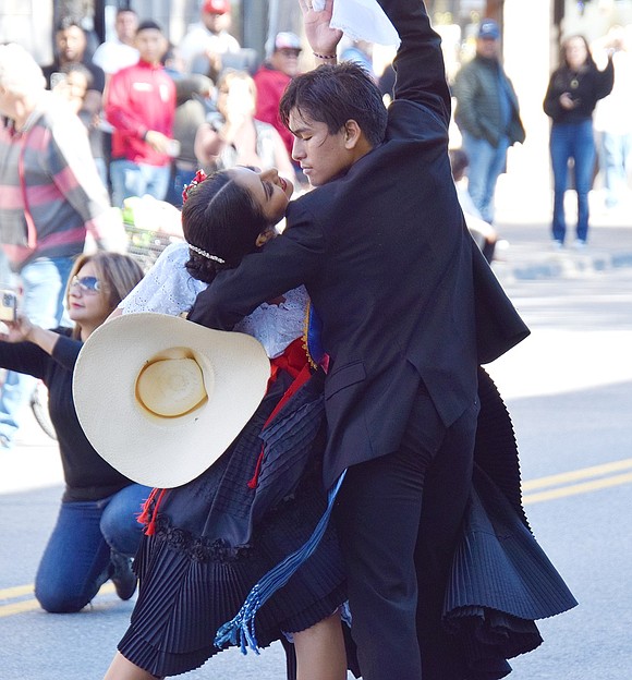 Striking a romantic pose, Sebastian Serrano, 16, and Lilian Chiroque, 18, bring grace and elegance to Westchester Avenue as they dance in the Columbus Day Parade with the Port Chester-based Academia de Marinera Somos Camperones on Sunday, Oct. 9.