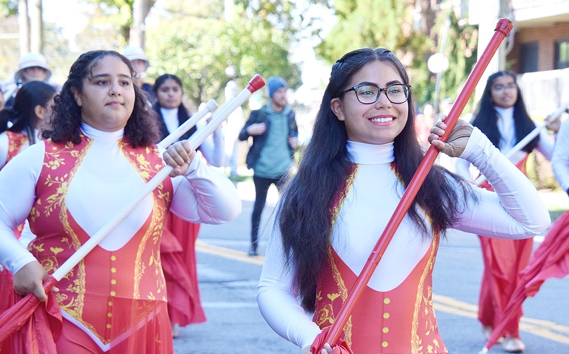 A bright smile extends across the face of Port Chester High School Marching Band color guard member Natalia Aguilar, a senior, as she struts down Westchester Avenue with poise.