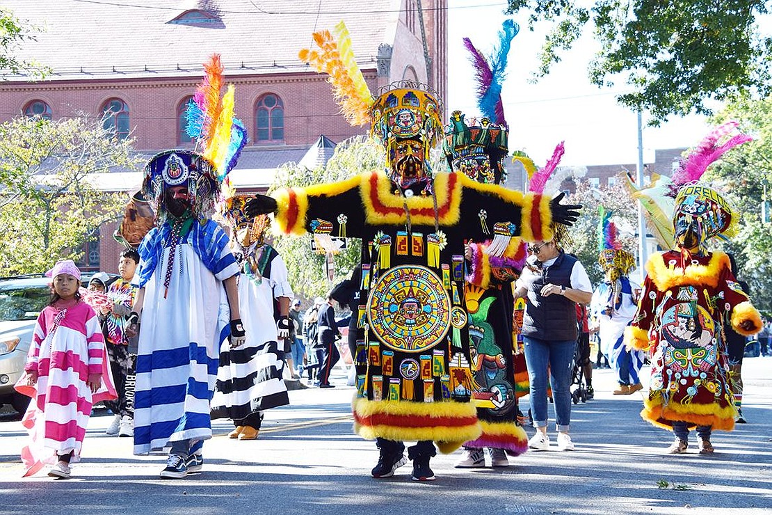 Just past the Parish of St. John Bosco, dancers with Comparsa Candelaria display their exquisite garments as they saunter down the road.