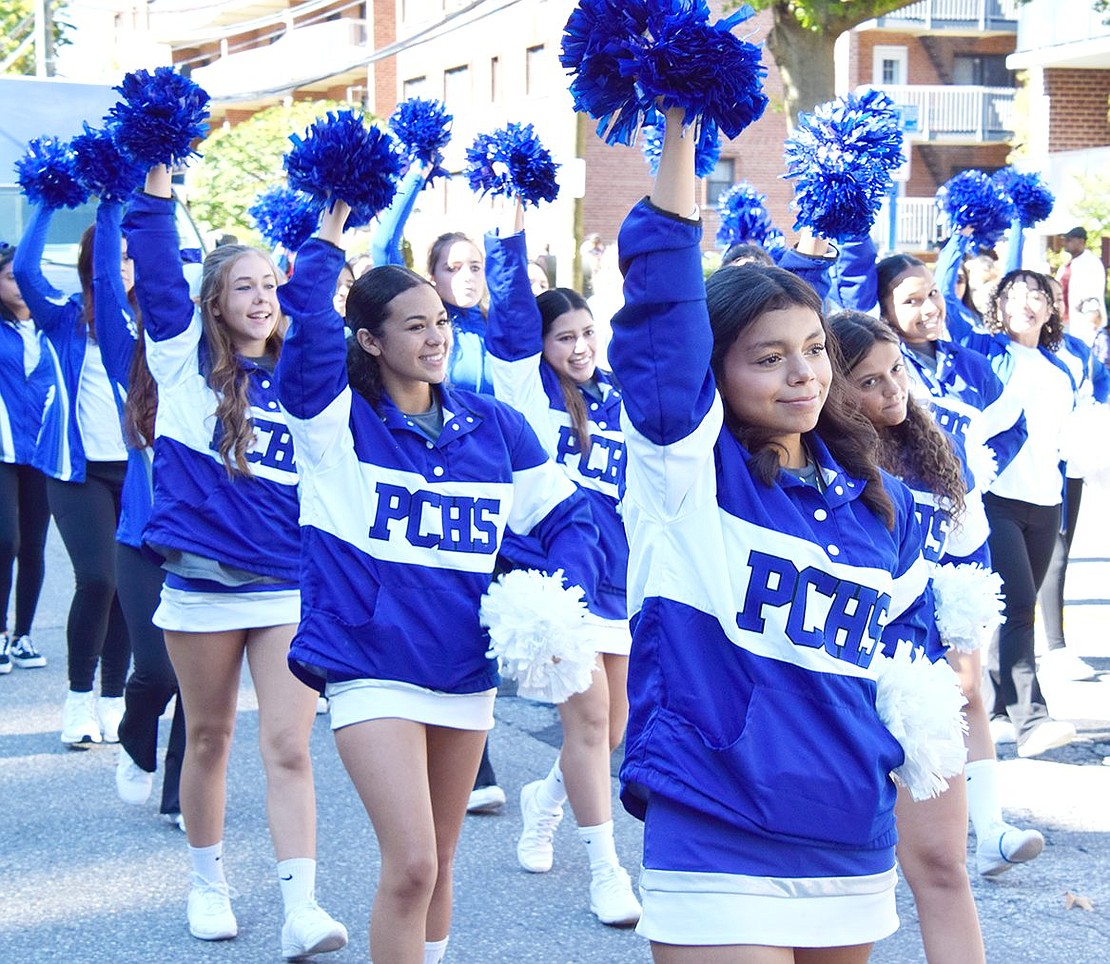 Bringing the Ram-pride spirit to the Columbus Day Parade, Port Chester High School cheerleaders wave their pom-poms high while they march.